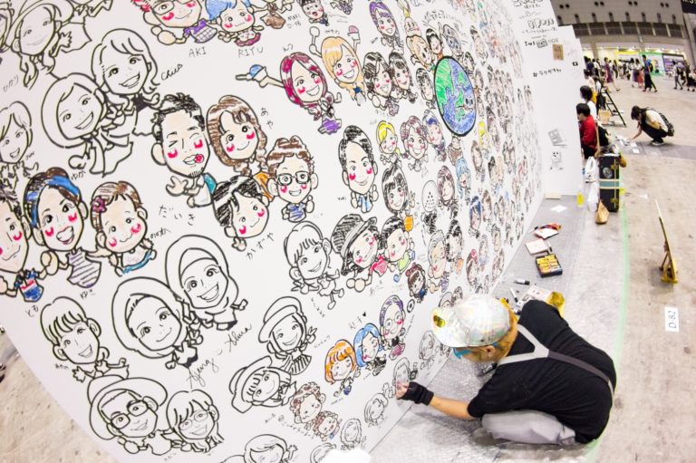 会場で似顔絵を描き込んでいるところ